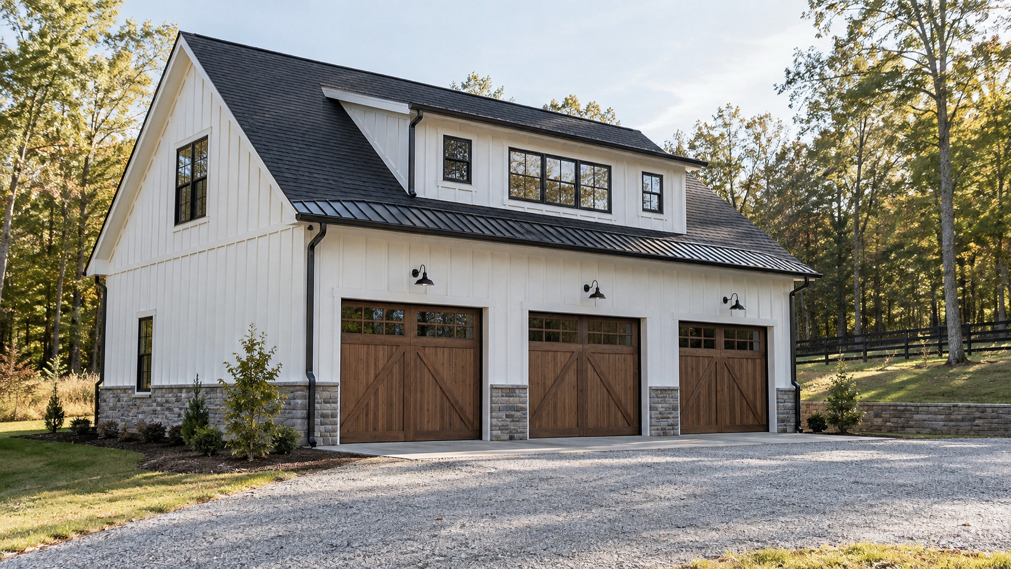 Custom garage and workshop with three carriage doors, board-and-batten siding and a stone base